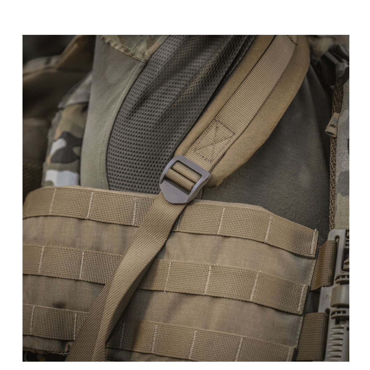 Ruskea M-Tac Large Assault Pack -reppu MOLLE-järjestelmällä ja säädettävillä olkahihnoilla, lähikuva kantohihnasta.