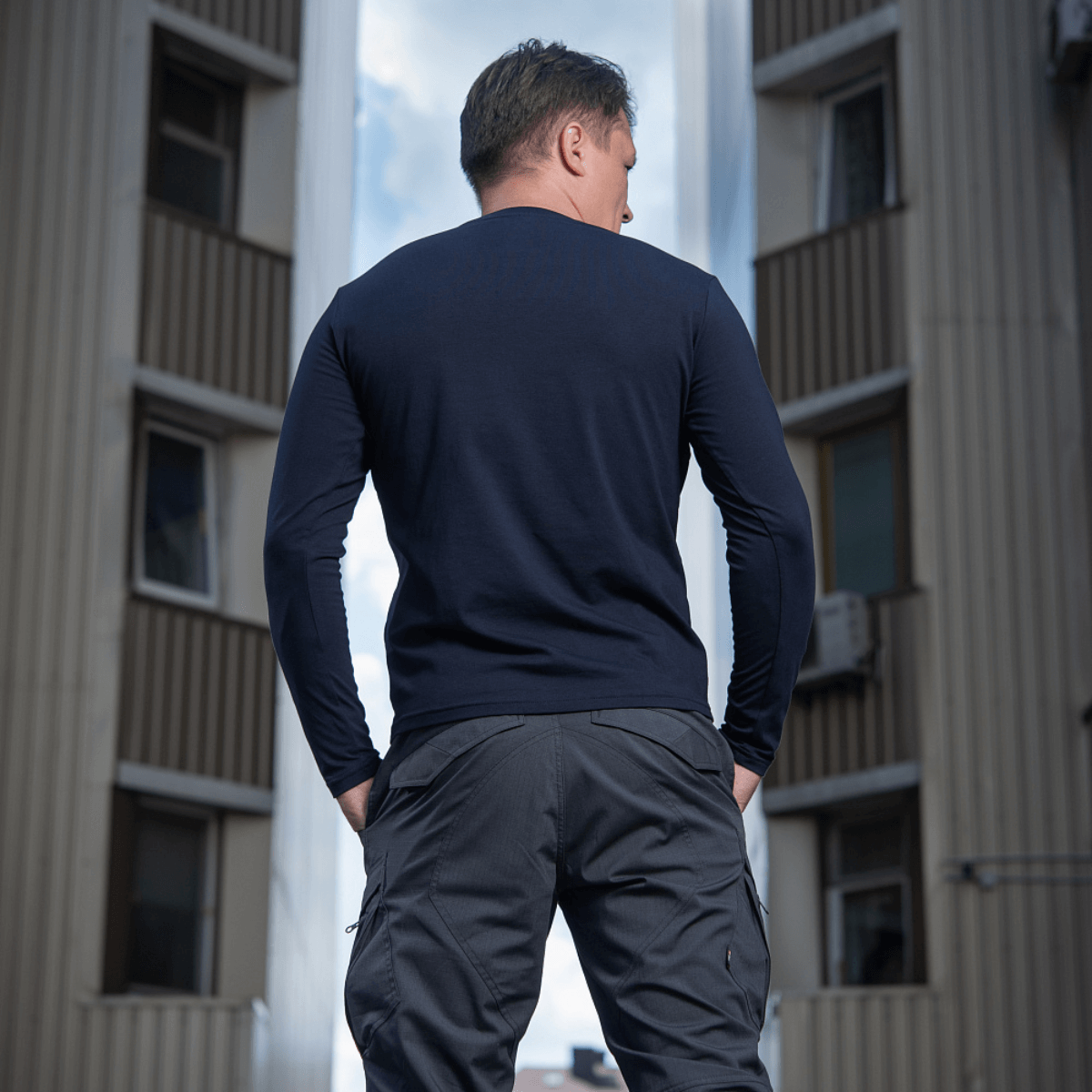 Mies M-Tac Long-sleeve T-shirt 93/7 päällä kaupunkiympäristössä, näyttää kestävän istuvuuden ja tyylikkään designin.