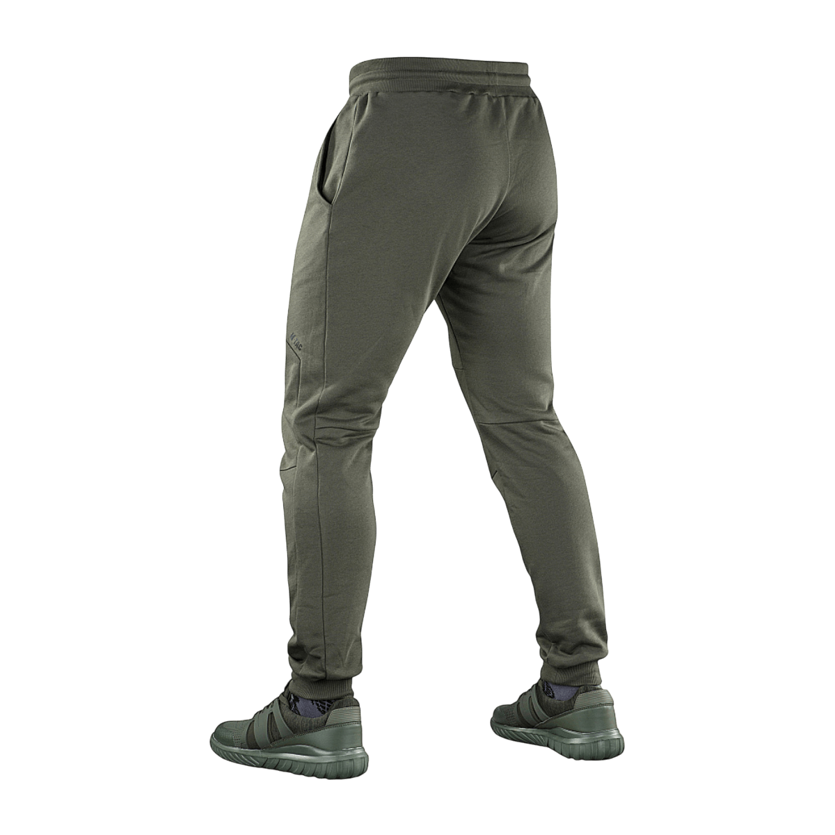 M-Tac Stealth Cotton -housut 100% puuvillaa kuminauhalla vyötäröllä ja kahdella sivutaskulla, suunniteltu juoksuun ja kuntosalille, nähtynä takaa.