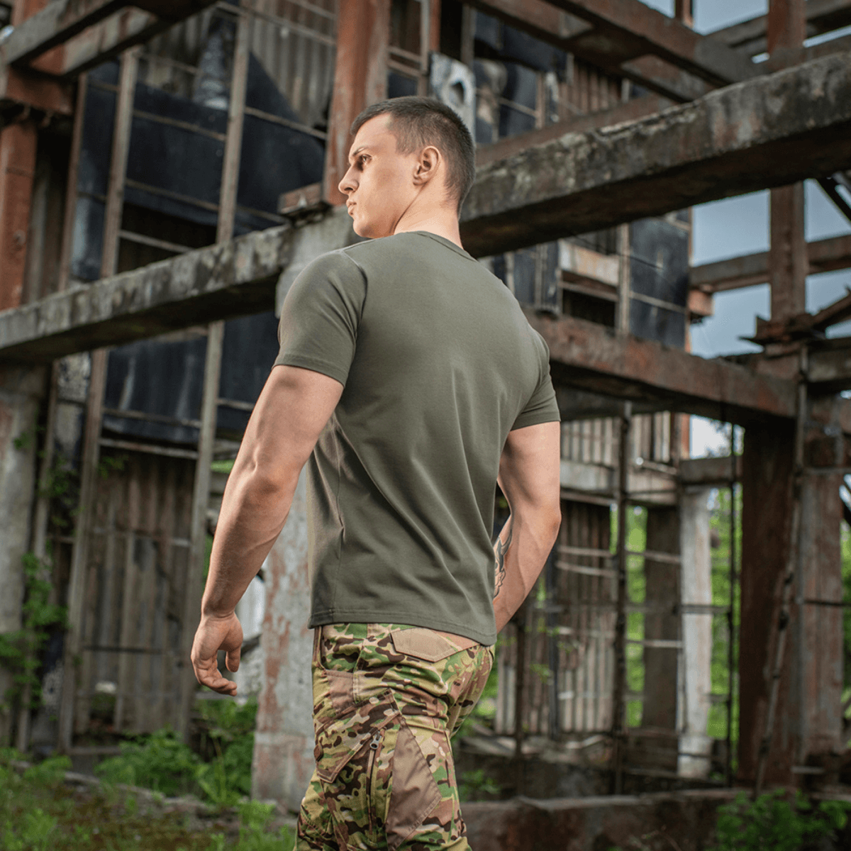 Mies pukeutuneena M-Tac T-shirt 93/7 Summer, kevyt ja hengittävä, sopii kesävaatteisiin, nähty takaa kaupunkiympäristössä.
