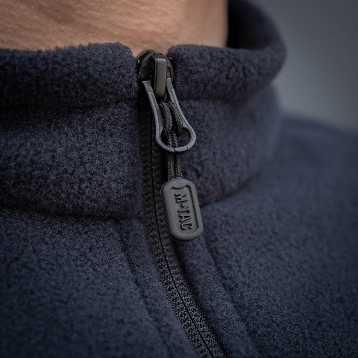 Lähikuva M-Tac Nord Polartec -fleecetakin vetoketjusta, näyttää laadun ja yksityiskohdat Polartec® 200 Series -fleece-kankaassa.