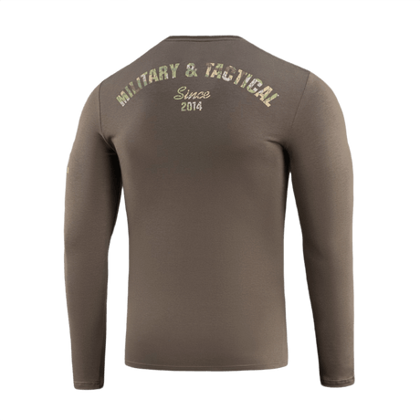 M-Tac T-Shirt Logo Long Sleeve maastokuvio ja slogan 'Military & Tactical Since 2014' takana.