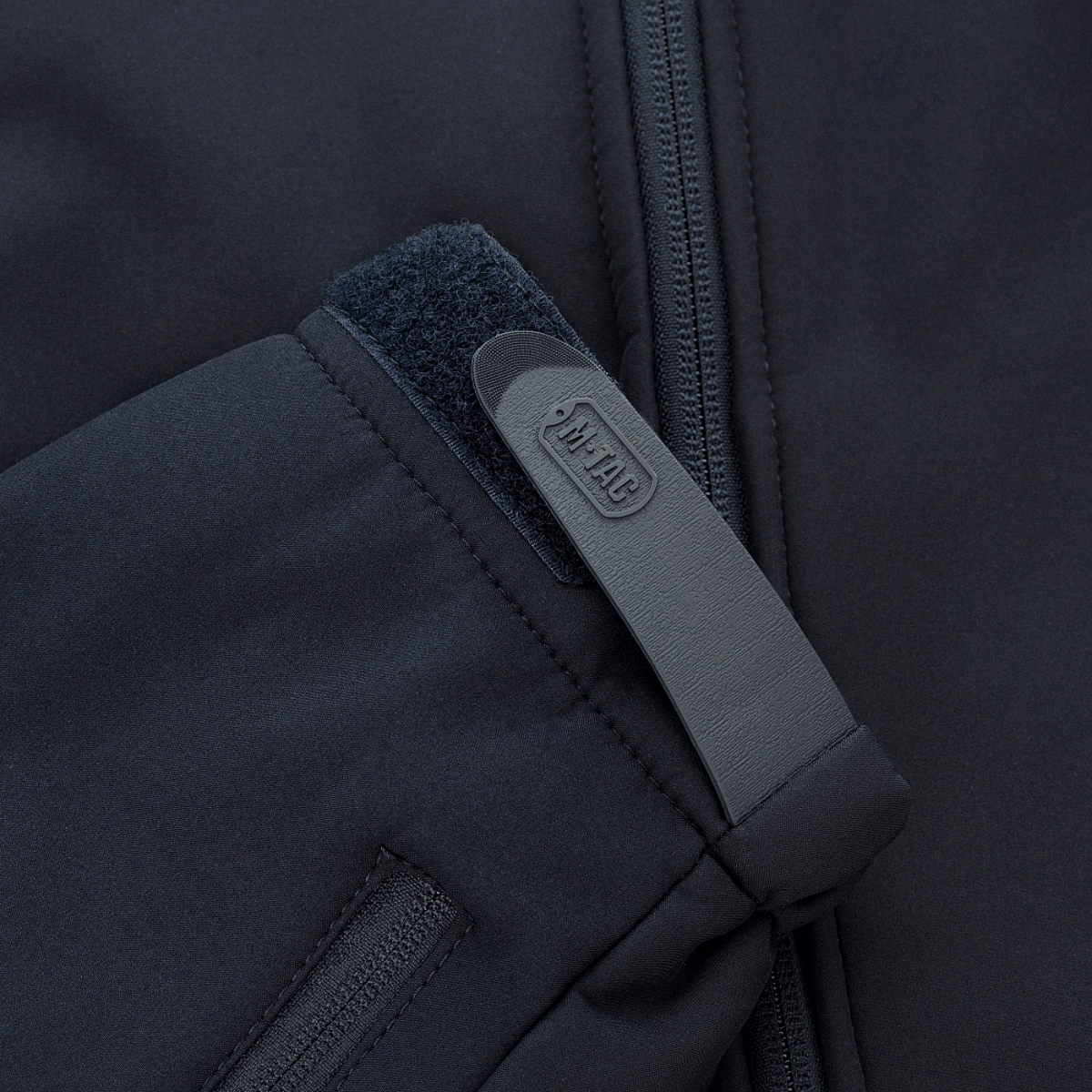 M-Tac Soft Shell Jakke med Liner — yksityiskohta vetoketjusta ja Velcro-lukosta mustassa designissa.