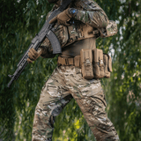 M-Tac War Belt ARMOR sotilaalla, näyttää kestävyyden ja MOLLE-järjestelmän luonnonympäristössä.