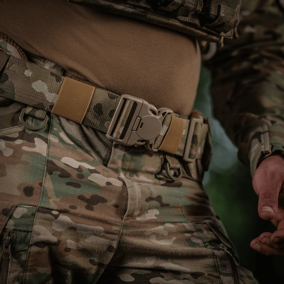 Sotilas käyttäen M-Tac War Belt ARMORia MOLLE-webbingillä ja kestävillä solki sulkimilla, suunniteltu taktisiin tehtäviin.