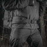 M-Tac Rygsæk Gen.II Elite Large kantajana henkilö talvivaatteissa metsässä, valmistettu kestävästä Cordura-materiaalista maksimaalista kestävyyttä varten.
