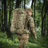 M-Tac Rygsæk Gen.II Elite Large, henkilö camokuvioisena repun kanssa metsäympäristössä.