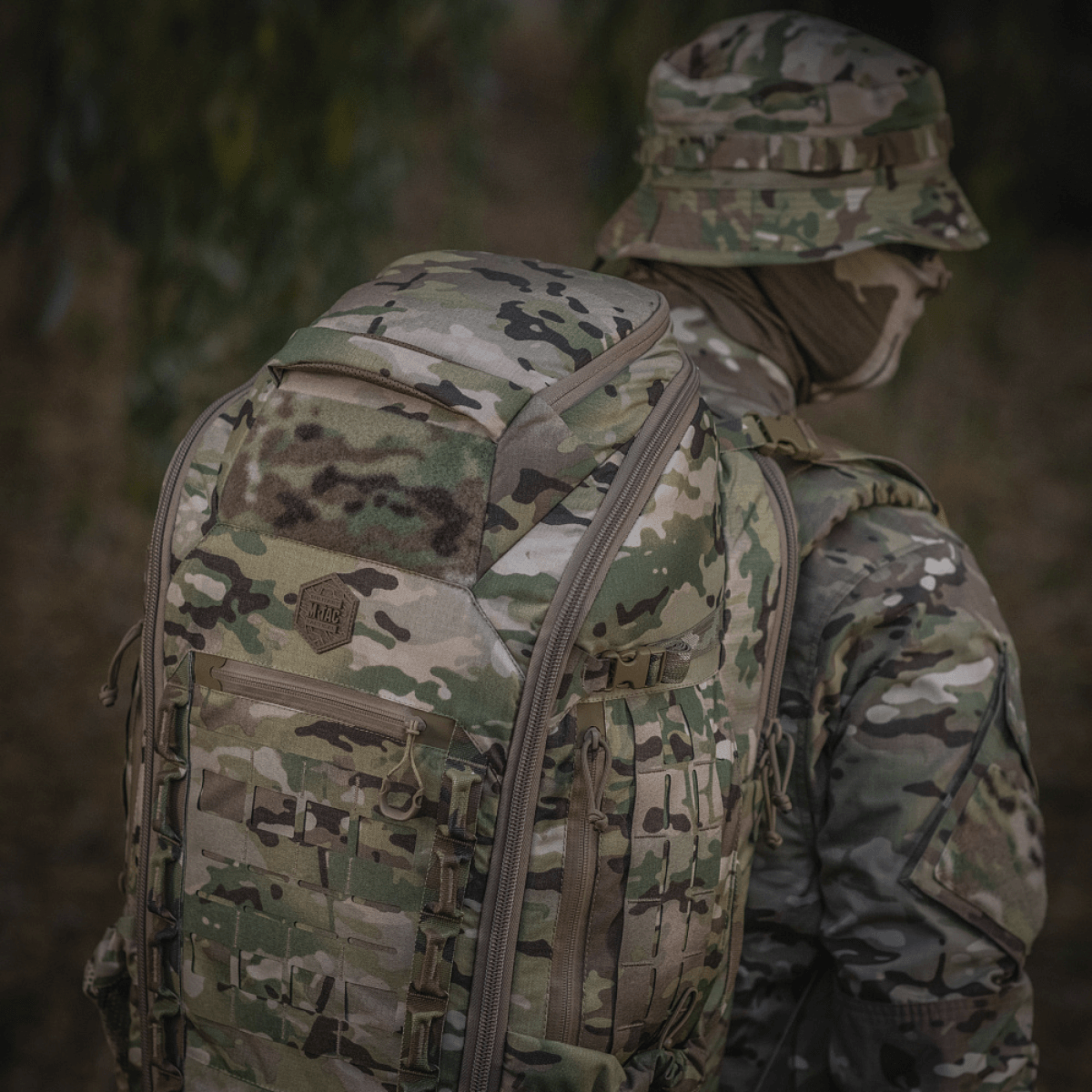 M-Tac Large Gen.IV Elite maastokuvioitu reppu ulkoilmassa, valmistettu kulumiskestävästä Cordura-materiaalista.