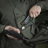 Henkilö käyttää M-Tac Double Mag Pouch Hook Backed Magazinea pistoolin lippaiden säilytykseen taktisessa laukussa