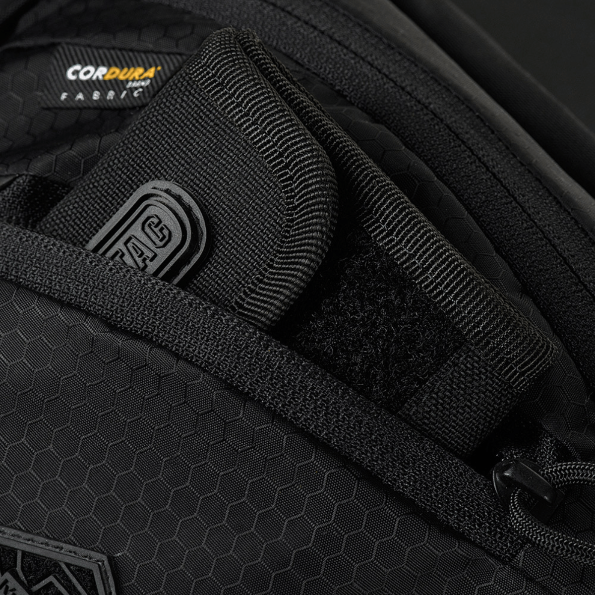 Lähikuva M-Tac Sphaera Hex Hardsling Gen.II Elite -laukusta, Cordura Hex -polyesteri, piilotettu kantotila ja vetoketjun yksityiskohdat.