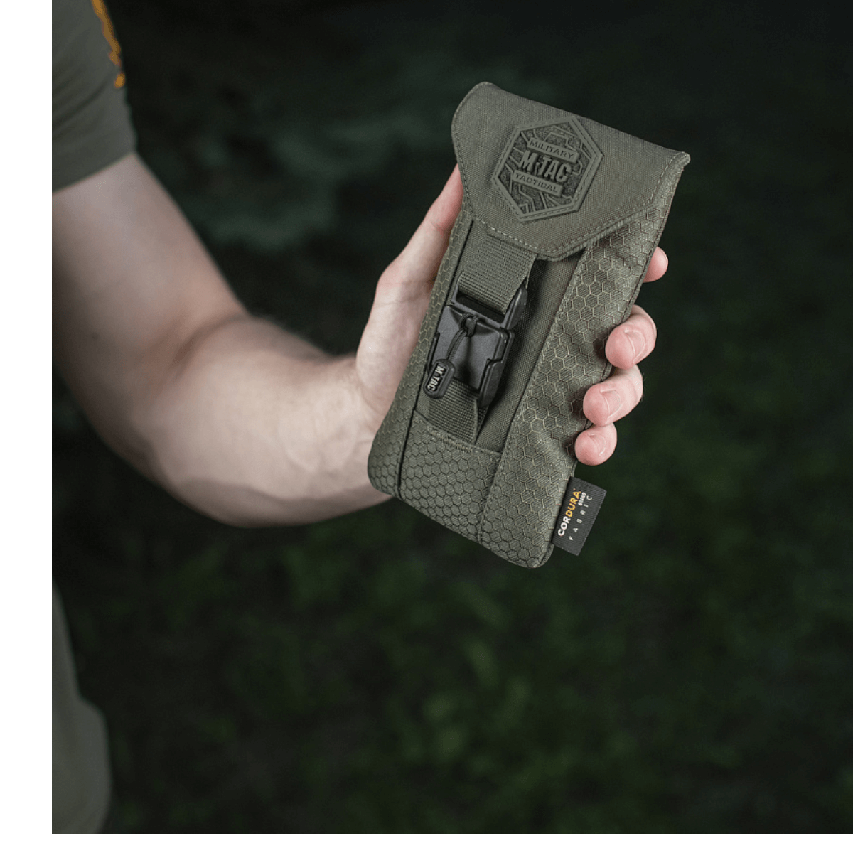 M-Tac Smartphone Lomme Elite Large Hex kädessä, valmistettu kestävästä CORDURA HEX -materiaalista WJ-magneettisoljella, musta muotoilu.