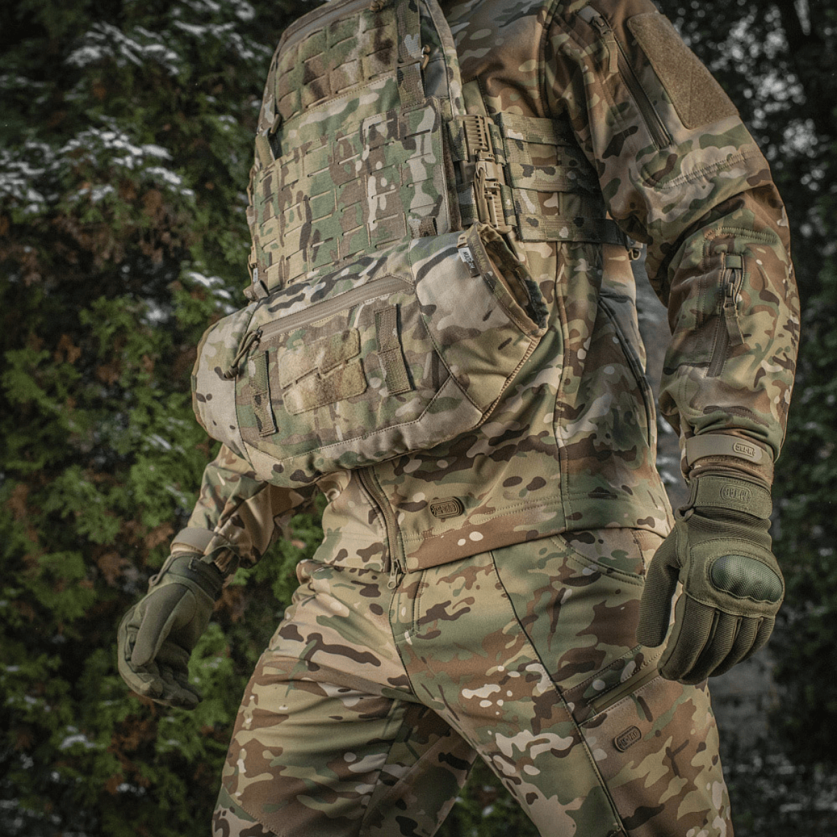M-Tac taktinen käsilämmitin Elite käytössä kamokuvioidun univormun päällä lämpimään mukavuuteen kylmässä säässä, valmistettu kestävästä Cordura 500D:stä.