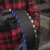 Henkilö pitelee M-Tac Bandolier Elitea, patruunavyötä jossa 55 patruunapaikkaa, sopii metsästykseen ja ampumaurheiluun.