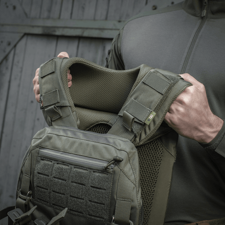 Henkilö esittelee M-Tac olkatyynyn Plate Carrier Cuirass QRS, korkealaatuinen Cordura ja 3D-mesh mukavuuteen ja tuuletukseen