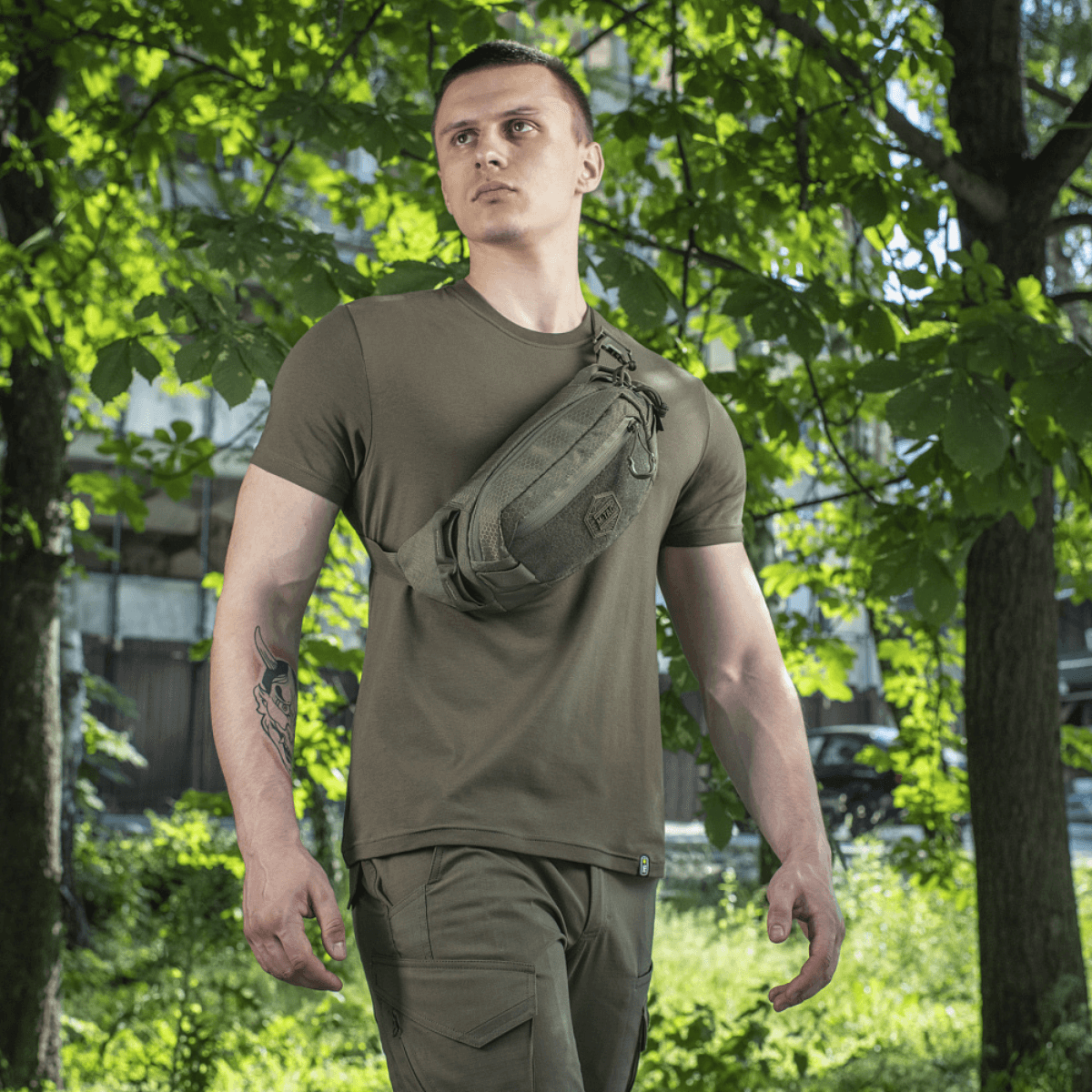 Mies käyttää M‑Tac Bæltetaske Elite Hexiä luonnossa, sopii arkeen, Cordura 500D ja Woojin-soljet näkyvissä.