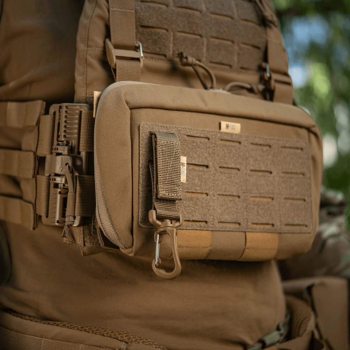 M-Tac karabiinihaka-lisävaruste kiinnitetty taktiseen MOLLE-reppuun, integroitu Velcro-remmillä ja YKK-soljella.