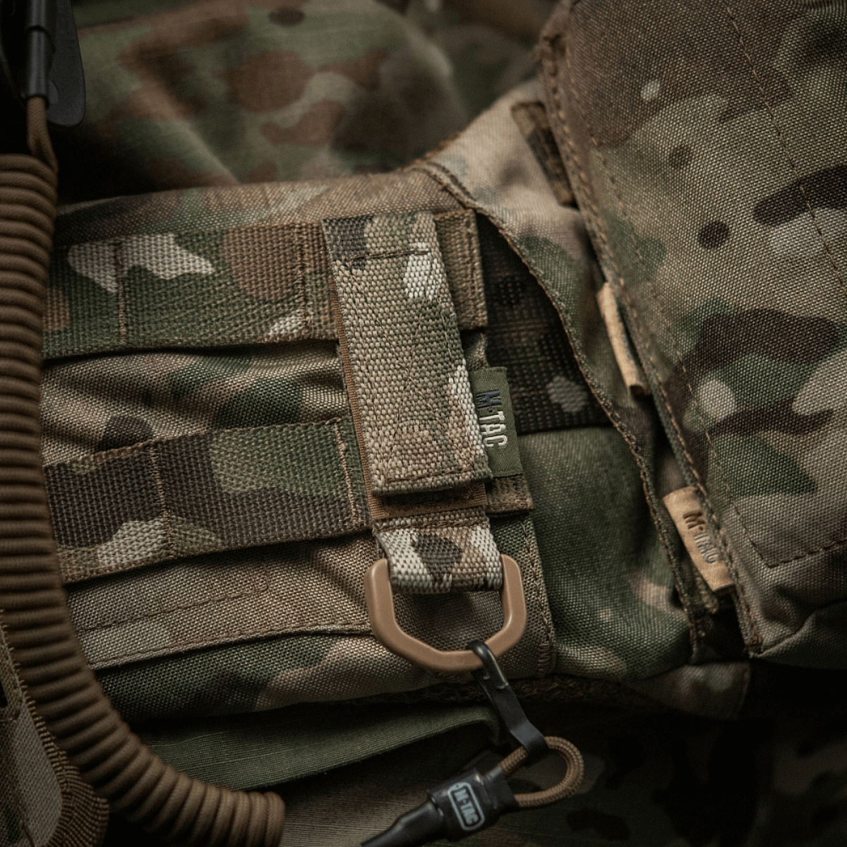 M-Tac-kiinnike D-renkaalla camouflage-liivissä MOLLE-järjestelmällä ja Velcro-sulkimella, sopii taktiseen kiinnitykseen.