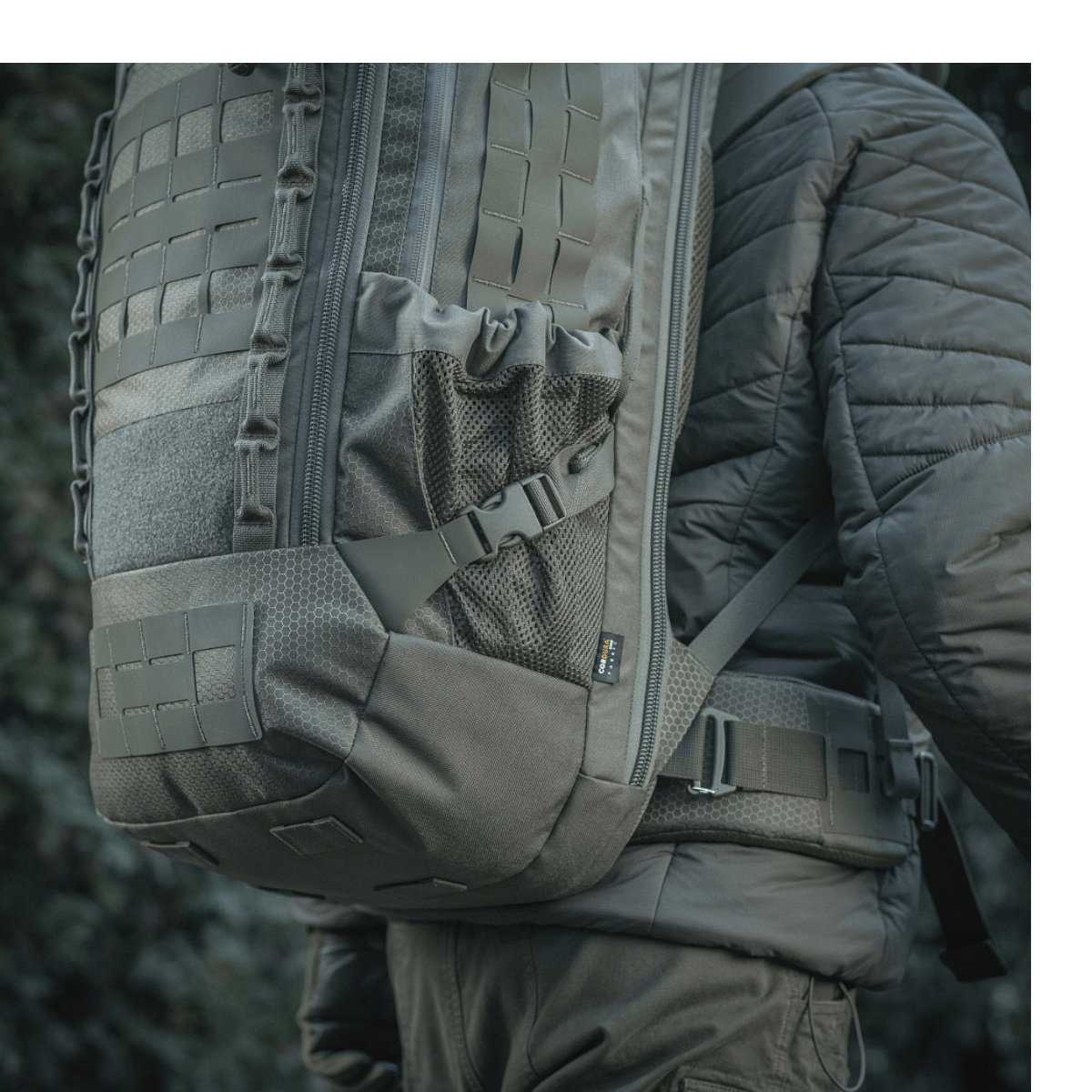 M-Tac reppu Large Elite Hex Gen. IV kantaa henkilö, näyttää repun tyylikkään ilmeen ja kestävät materiaalit kuten Cordura 500D ja Hex 1000.
