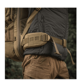 M-Tac reppu Large Elite Hex Gen. IV kantaa henkilö selässä ulkovaatteissa, sivulta luonnollisessa ympäristössä.