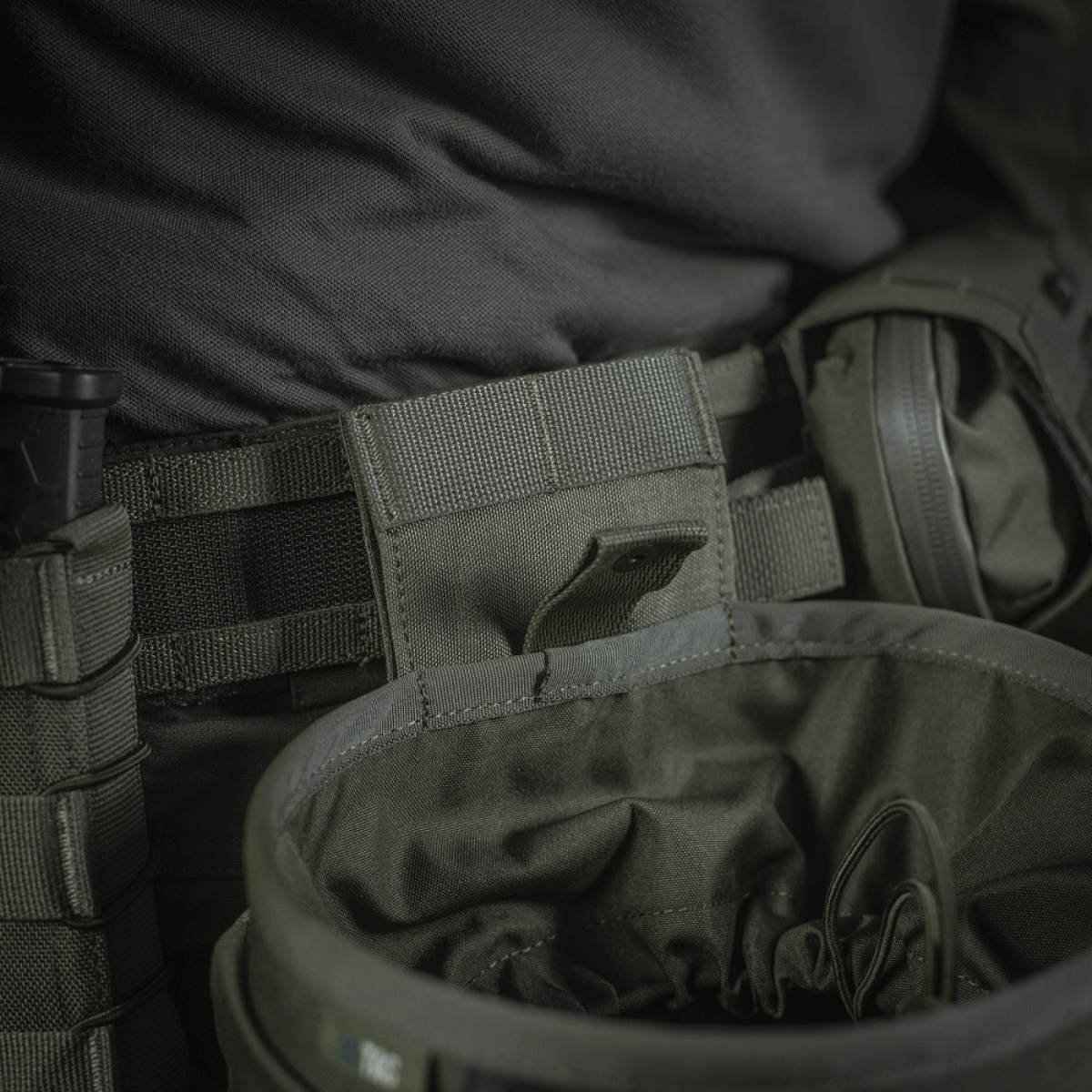M‑Tac Magasinsæk Dump Pouch Lite Elite kiinnitetty vyöhön, korostaa quick-pull-sulkua ja kestävää Cordura 500D -materiaalia.
