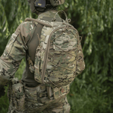 M-Tac STURM Elite -reppu käytössä, taktinen reppu camo-kuosilla lyhytaikaisiin kenttäoloihin, valmistettu Cordura-materiaaleista.