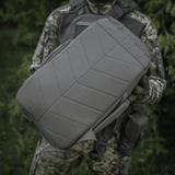 M-Tac STURM Elite -reppu taktiseen käyttöön 15 l kapasiteetilla ja kulutusta kestävä Cordura-materiaali, pidetään maastopuvun käyttäjän toimesta.