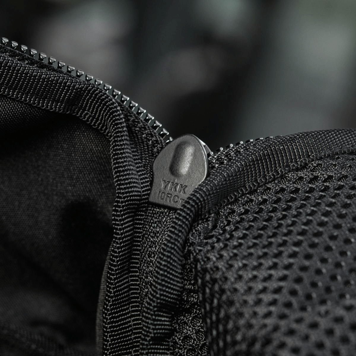 Lähikuva YKK-vetoketjusta M-Tac STURM Elite -repun Cordura-materiaalissa.