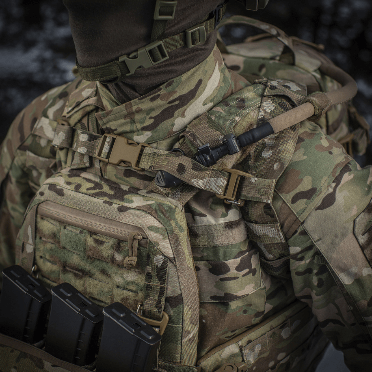M-Tac reppu Sturm Elite Gen.II maastokuvioinnilla, MOLLE-järjestelmällä ja sisäänrakennetulla juomajärjestelmällä, kuvattu kenttäasetelmassa.