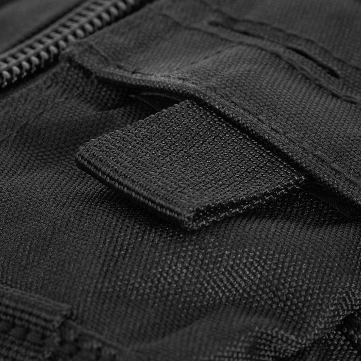 Lähikuva vetoketjun vetonauhasta ja kestävästä polyesterikankaasta M-Tac Assault Pack Laser Cutissa.