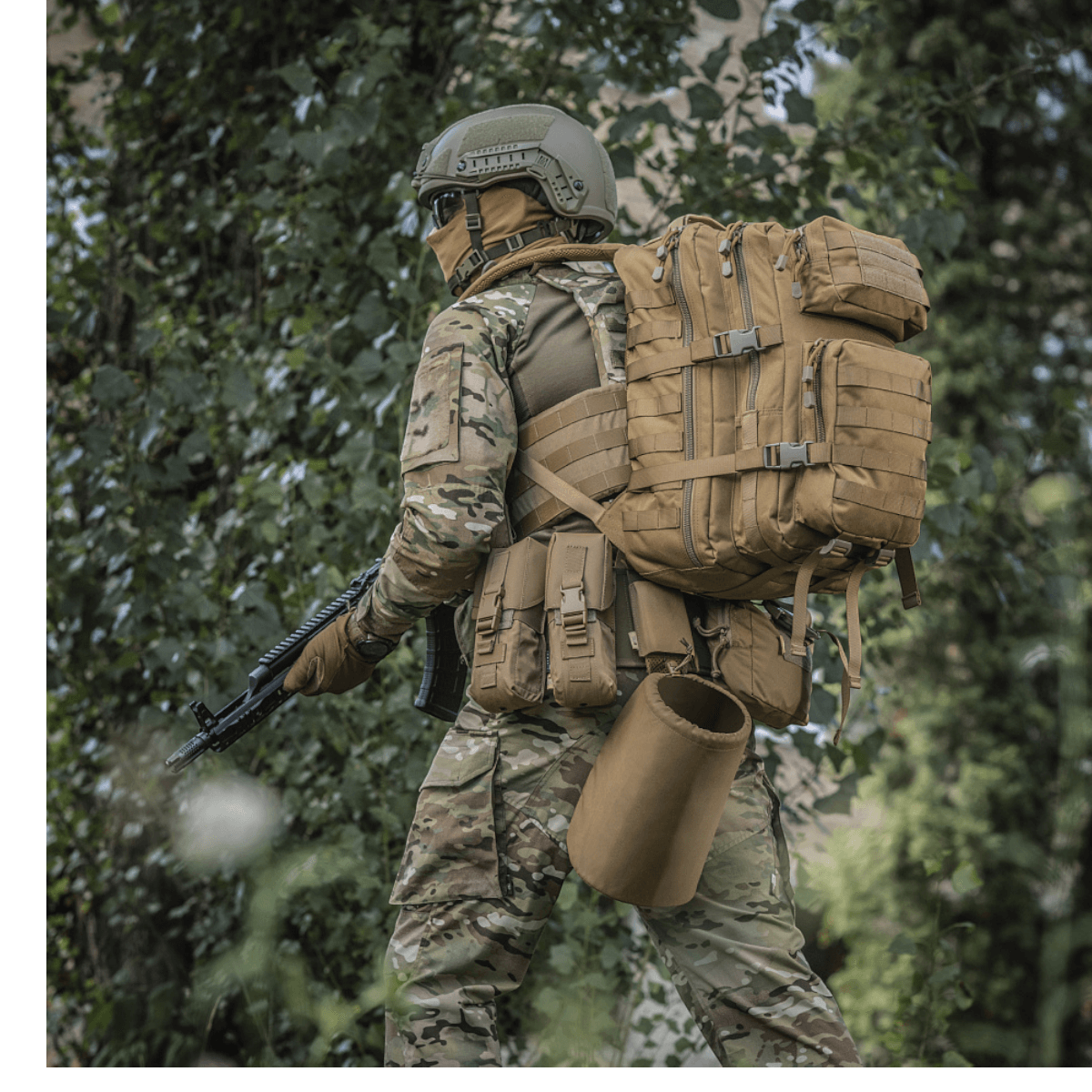 M-Tac Large Assault Pack -reppu käytössä henkilöllä maastopuvussa metsäympäristössä, MOLLE-järjestelmä ja säädettävät olkahihnat.