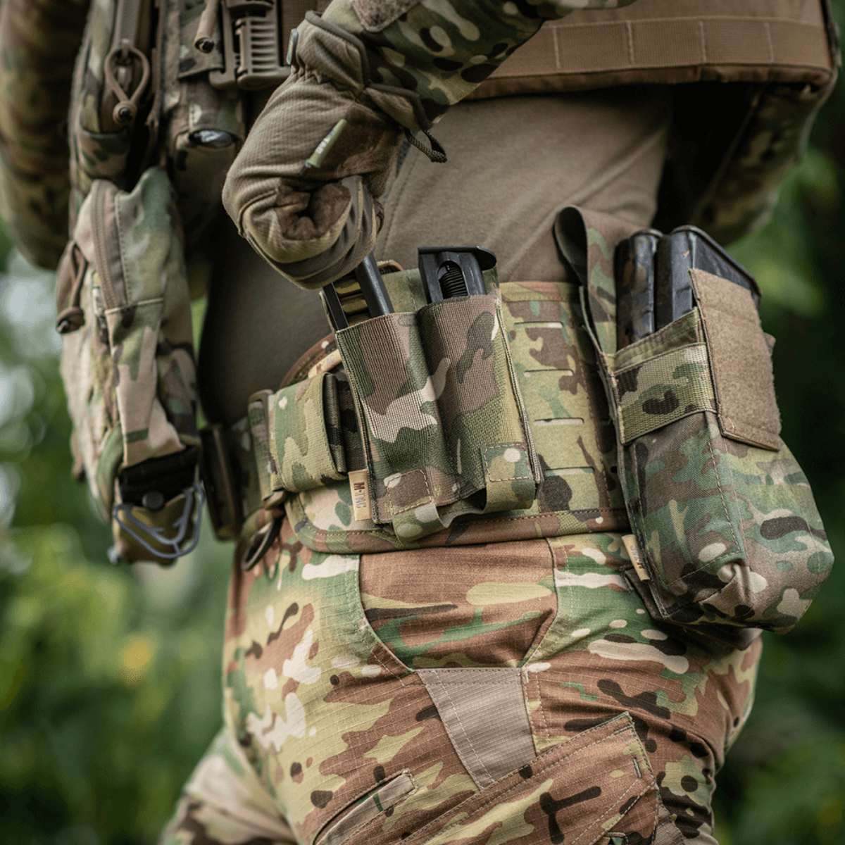 M-Tac Double Magazine Pouch APS Laser Cut sotilaan päällä camo-univormussa, näyttää käytettävyyden ja kestävyyden kentällä.