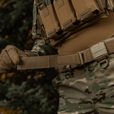 M-Tac Range -vyö Cobra Buckle Gen.IV käytössä sotilaspuvussa, näyttää vyöjärjestelmän lippaataskuilla ja maastokuvioinnin.