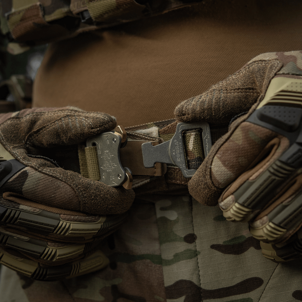 Lähikuva M-Tac Range -vyöstä Cobra Buckle Gen.IV taktisten hanskojen kanssa, suunniteltu sotilas- ja poliisisovelluksiin.