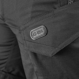 Yksityiskohta M-Tac Shorts Aggressor Shortista näkyvällä taskulla ja M-Tac-logolla, valmistettu kestävästä rip-stop-kankaasta.