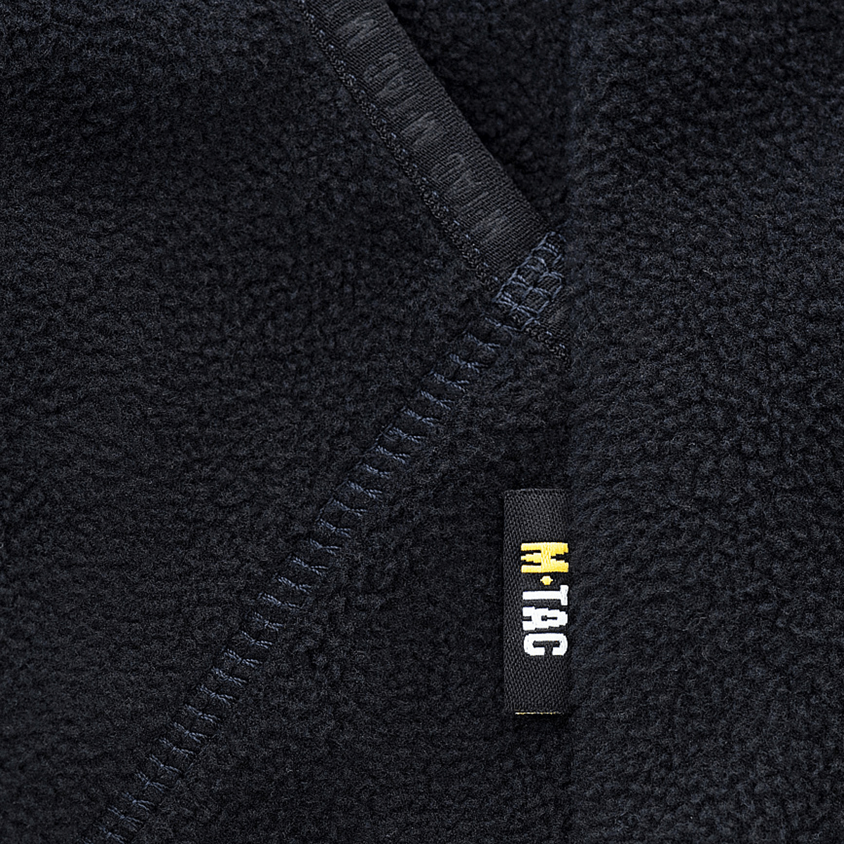 Lähikuva M-Tac Lite Microfleece Hættetrøje -yksityiskohdista: joustava reuna ja logo mukavuuteen ja tyyliin