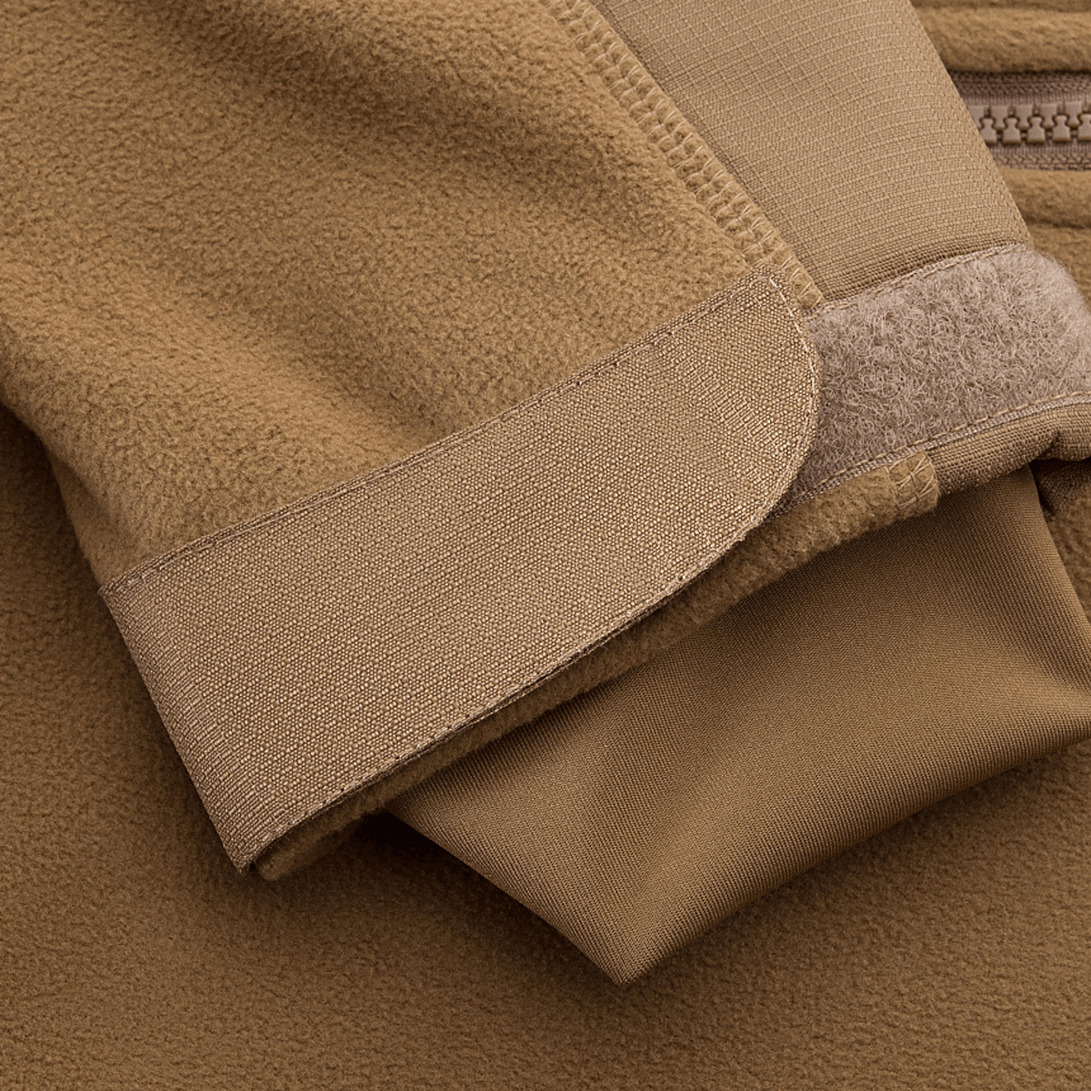 Lähikuva hiha­yksityiskohdasta M-Tac Norman Windblock Fleecejakke -takissa, beige WindBlock-materiaali ja Softshell-indlæg.