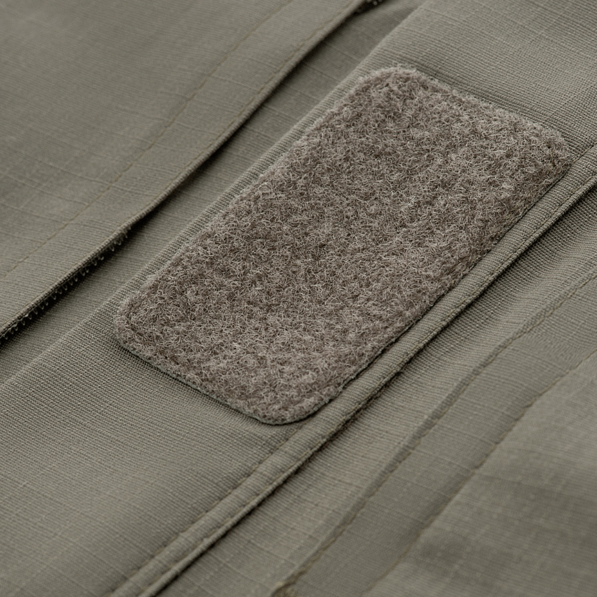 Lähikuva Velcro-paneelista M-Tac Patrol Flex -takissa, vaaleanharmaa kangas ripstop-kuviolla ja taktinen muotoilu.
