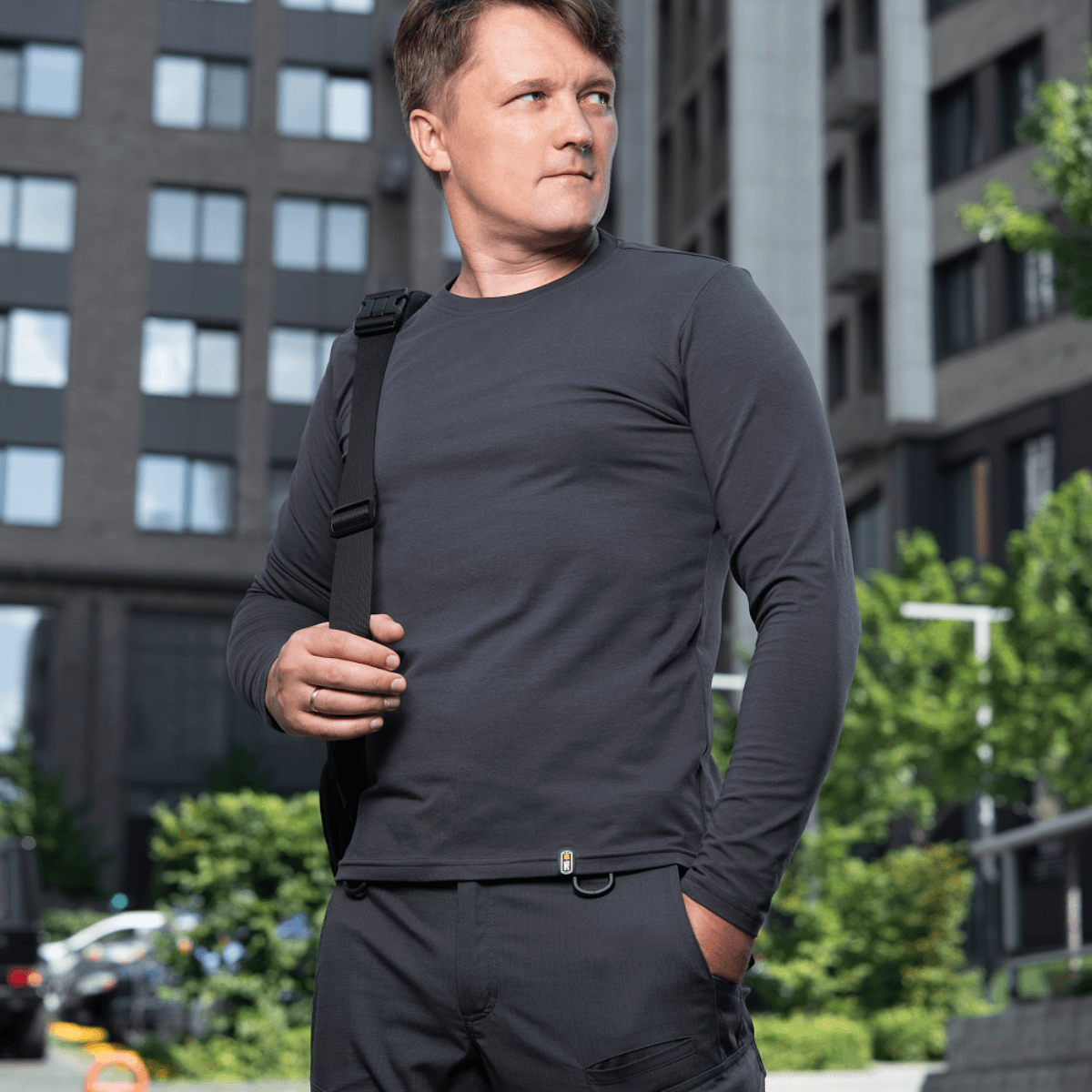 Mies M-Tac Long-sleeve T-shirt 93/7 päällä kaupunkitaustalla, sopii arkeen, univormuihin, urheiluun ja ulkoiluun.