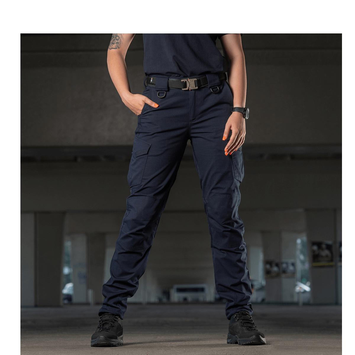 M-Tac Bukser Aggressor Dame Flex -housut naisella treenin aikana mustaa taustaa vasten, kevyt likahylkivä materiaali.