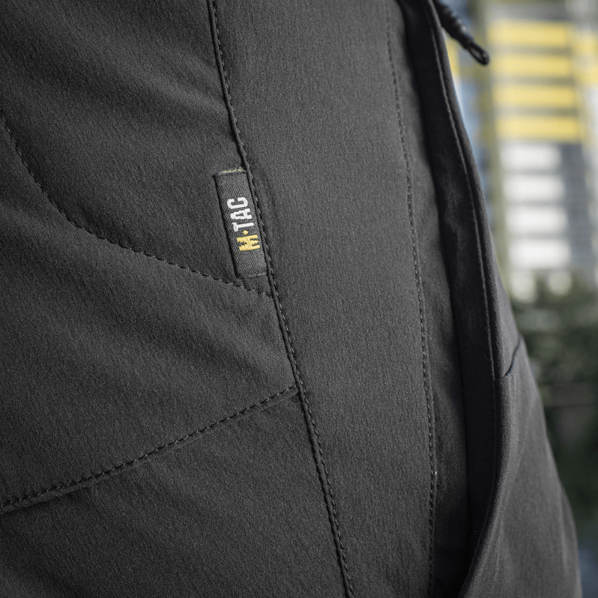 Lähikuva M-Tac Shorts Rubicon Flex -shortseista tumman oliivin värissä, näyttää cargotaskun suunnittelun maksimaaliseen liikkumisvapauteen.