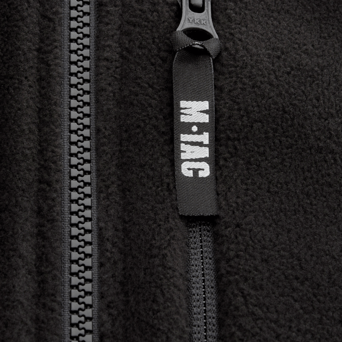 Vetoketjun yksityiskohta M-Tac Alpha Microfleece Jakke Gen.II -takissa vahvistetuilla materiaaleilla taktista käyttöä ja ulkoiluseikkailuja varten.