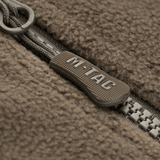 Lähikuva vetoketjusta M-Tac Alpha Microfleece takki Gen.II:stä, näyttää kulutuskestävän rakenteen ja fleece-kankaan yksityiskohdat.