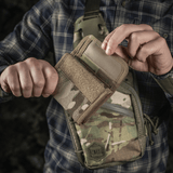 Henkilö pitelee M-Tac Pung Elite Gen.II:tä, valmistettu Cordura 500D:stä, M-Tac-logo ja YKK-vetoketjut. Sopii korteille, seteleille ja kolikoille.