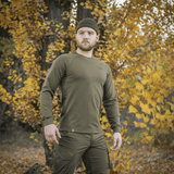 Mies pukeutuneena M-Tac Raglan Athlete -oliivinvihreä college syksyllä.