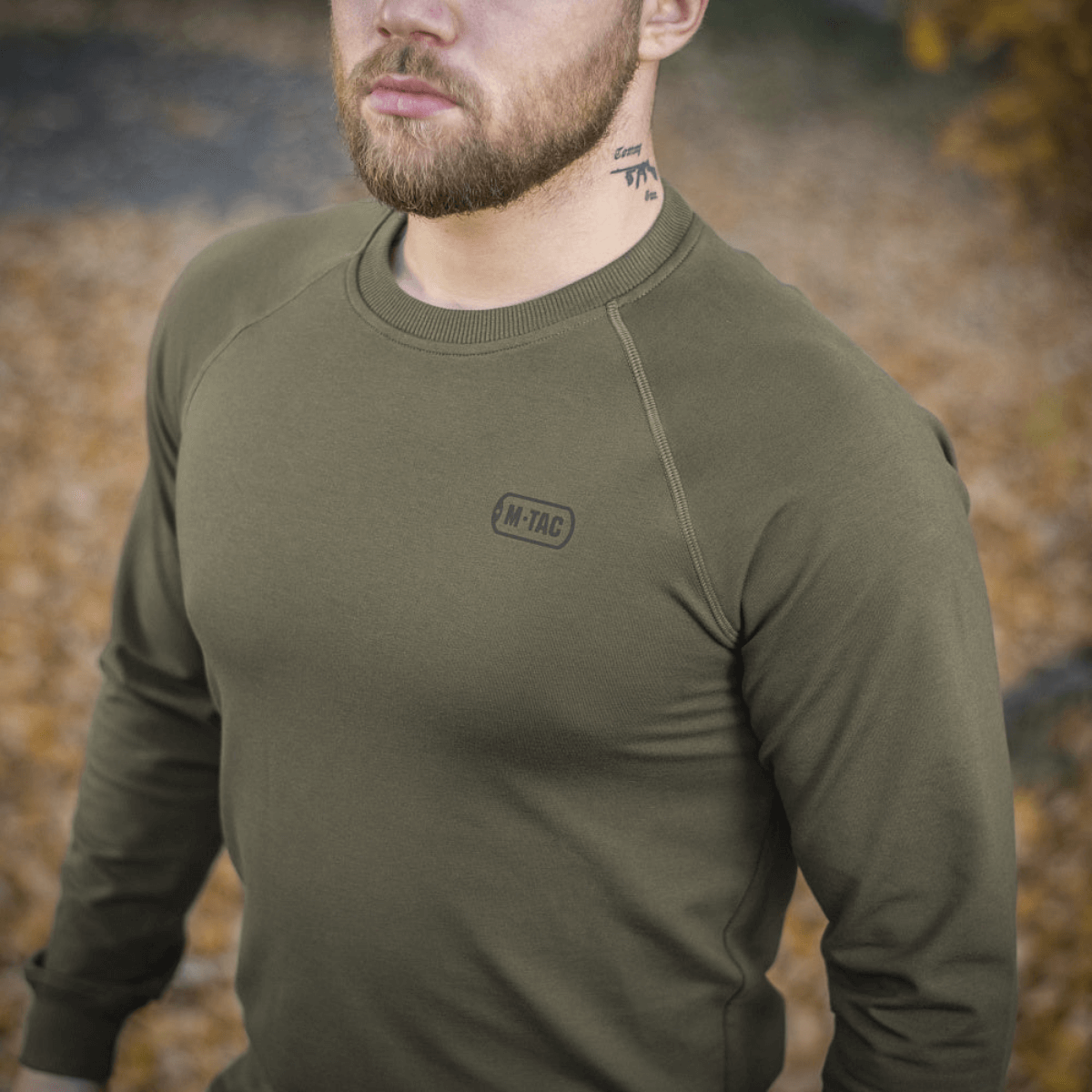 M-Tac Raglan Athlete oliivinvihreänä raglanhihoilla, sopii arkeen ja urheiluun, ulkona syksyn lehdissä.