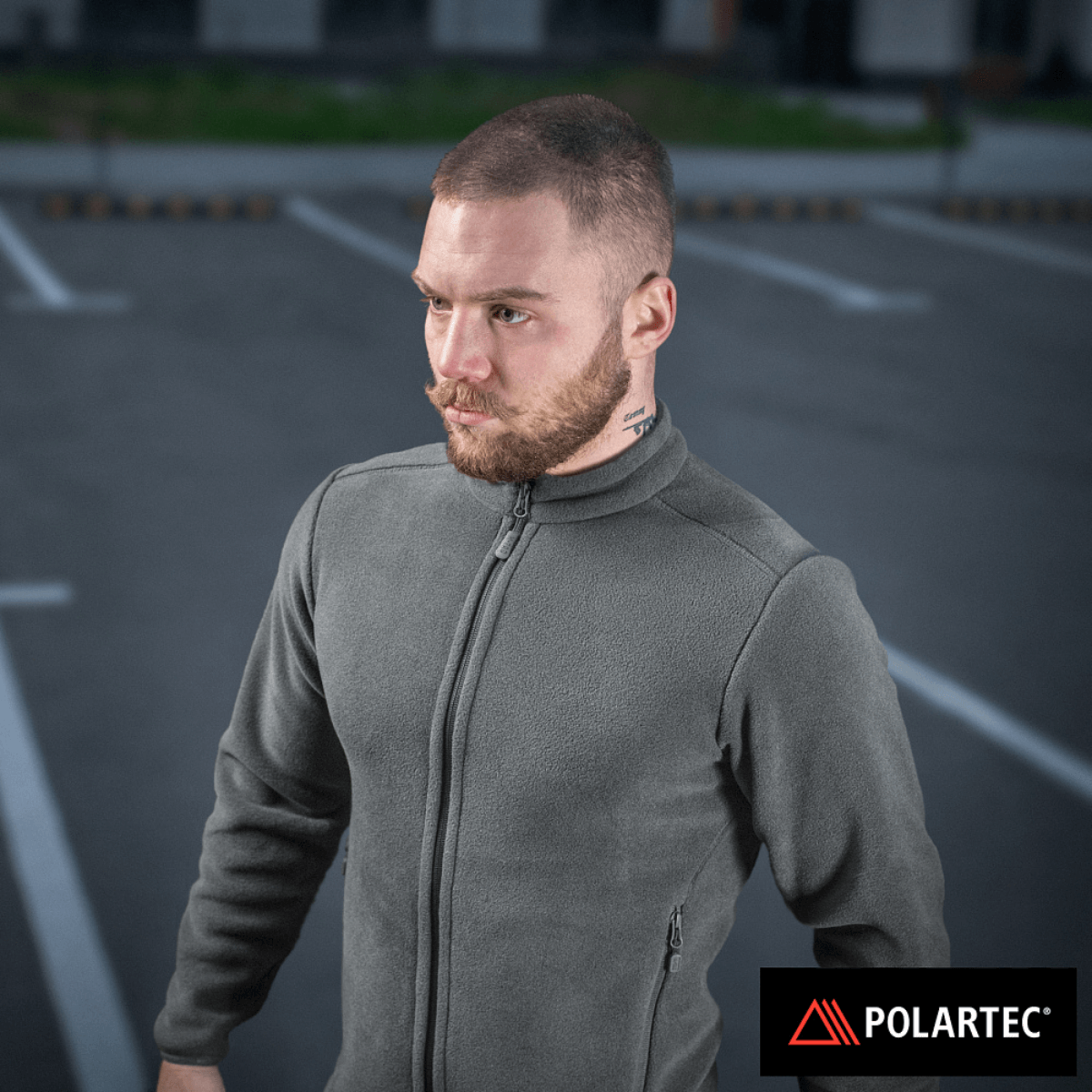 M-Tac Nord Polartec -fleecetakki harmaana, valmistettu Polartec® 200 Series -fleecestä, pidetty miehen yllä parkkipaikalla.