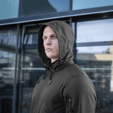 M-Tac Flash -takki minimalistisella muotoilulla, sopii ulkoiluun kuten retkeilyyn ja urheiluun, nähty henkilöllä rakennuksen edessä