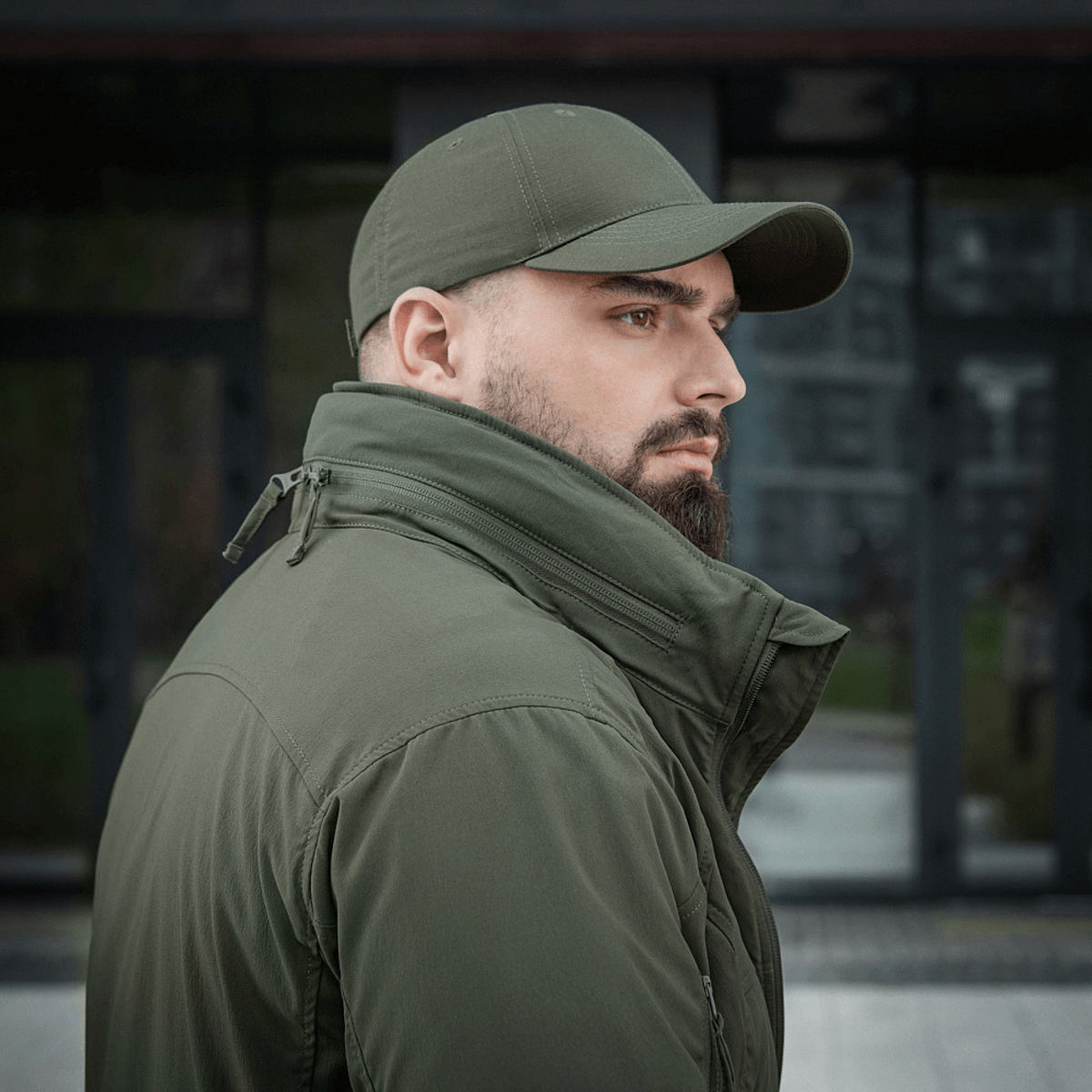 Mies pukeutuneena M-Tac Flash -takkiin, sopii ulkoiluun ja päivittäiseen käyttöön, neutraali käytännöllinen vihreä.