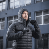 Mies pukeutuneena M-Tac Stalker Gen.III -takkiin modernin rakennuksen edessä