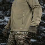 M-Tac Combat Fleece Polartec -takki käytössä, näyttää YKK-vetoketjut ja taktisen muotoilun.